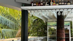 Un espace bar avec un assortiment de bouteilles d’alcool et de verres.