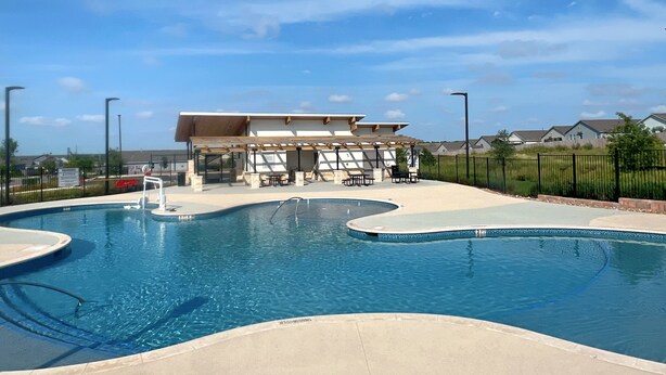 Una piscina con zona de estar cubierta y un pabellón.