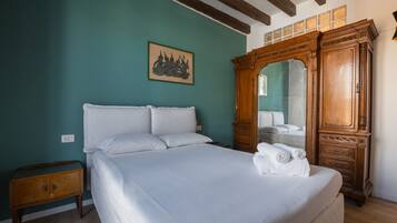 Una camera da letto con un letto grande, un armadio in legno e un quadro appeso al muro.