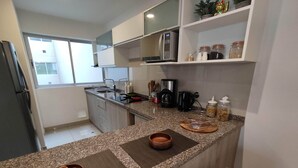 Eine moderne Küche mit Granit Arbeitsplatten, einer Mikrowelle, einer Kaffeemaschine und verschiedenen Küchenutensilien.