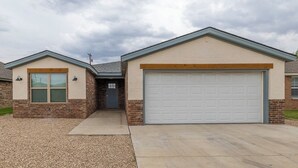 A two-story house with a garage, a front entrance, and a driveway.