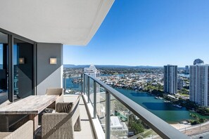 Un balcon avec vue sur un port de plaisance et sur le paysage urbain.