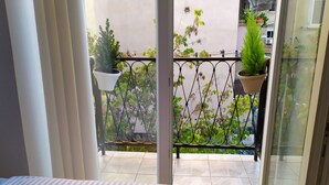 A balcony with potted plants and a view of the surrounding buildings. - A-1 · Cosy Modern Studio With Balcony in Blloku (Tiranë)