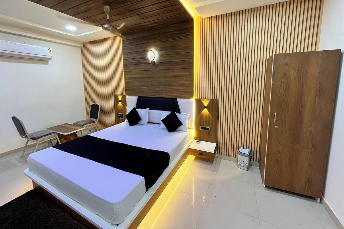 A modern bedroom with a bed, bedside tables, a wardrobe, and a desk with a chair.