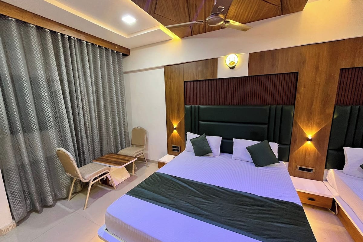 A modern hotel room with a large bed, a desk, and a chair.