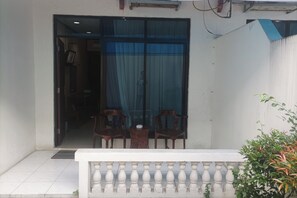 A room with a large window, a white balustrade, and two wooden chairs. - Hotel Efita (Bogor)
