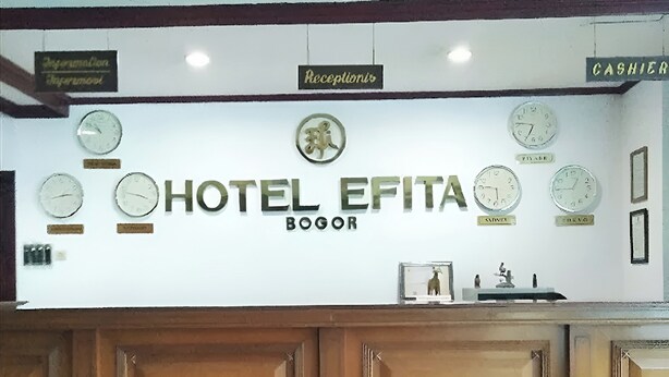 A reception area with a sign for Hotel EFITA Bogor, featuring clocks and a reception desk. - Hotel Efita (Bogor)
