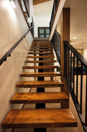 Eine Holztreppe mit schwarzen Geländern und einem Teppichboden.