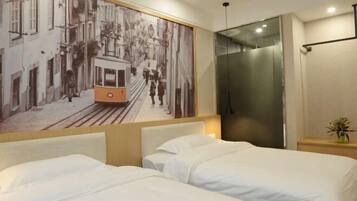 A hotel room with two beds, a large wall mural of a tram, and a modern elevator.