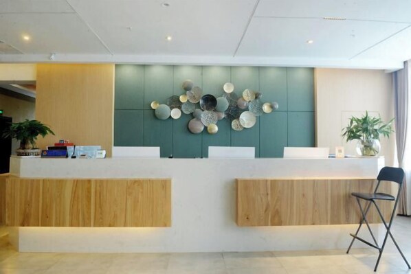 A reception desk with a modern design, featuring a light-colored counter and wooden accents. - Chongqing Yishi Rongtai Hotel (Chongqing)
