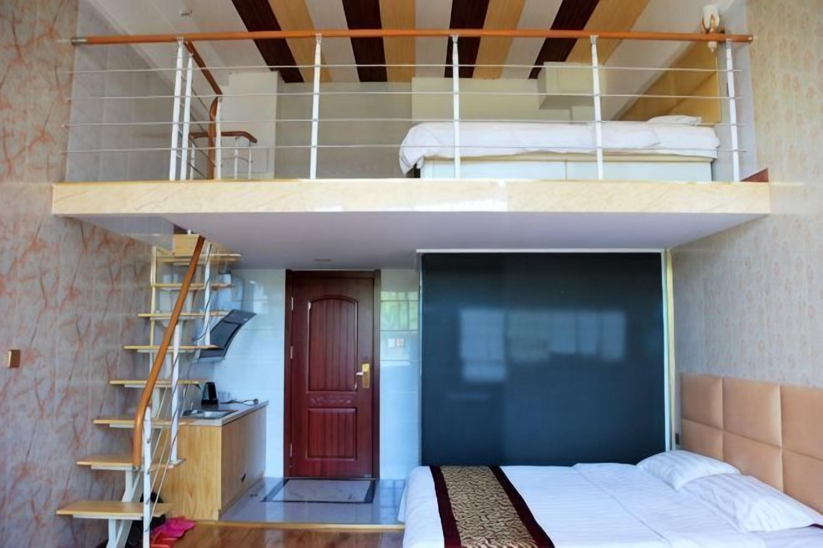 Una habitación con literas, un escritorio, una silla, una puerta y una ventana.