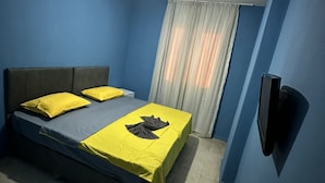 Un dormitorio con cama, cortinas y ventilador de techo.