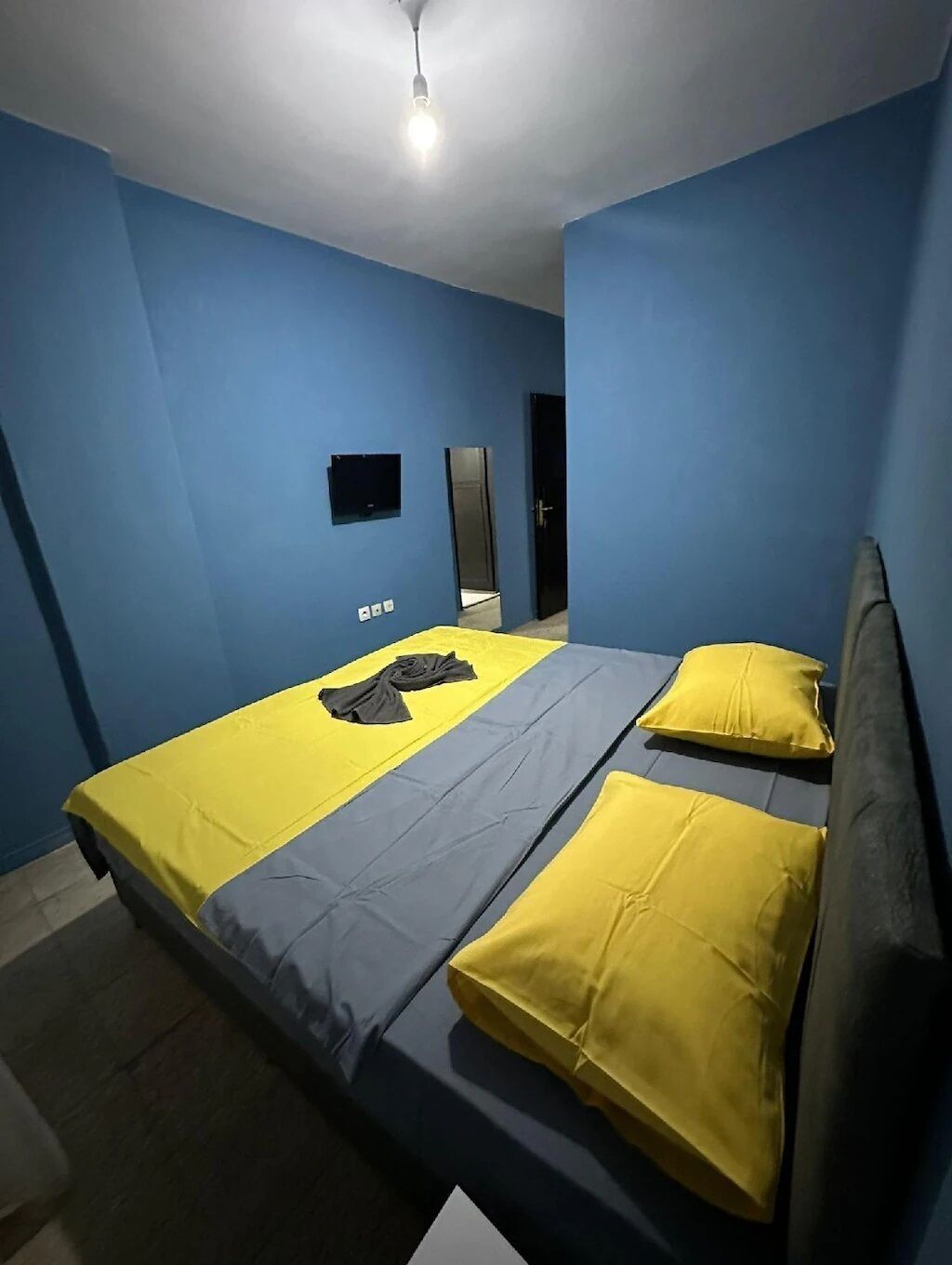 Una habitación con cama, espejo y luz en el techo.