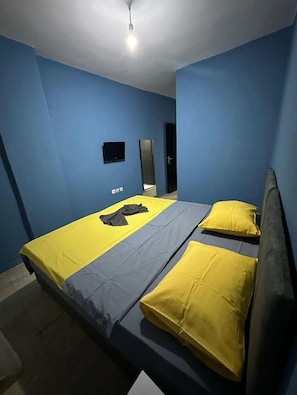 A room with a bed, a mirror, and a ceiling light.