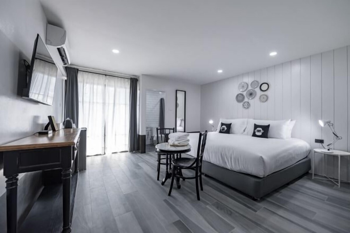 Ein modernes Hotelzimmer mit einem großen Bett, einem Schreibtisch und einem Sessel.