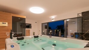 A modern spa room with a hot tub, wooden paneling, and a view of the outdoors. - Villa Mia 2 (Podbablje)