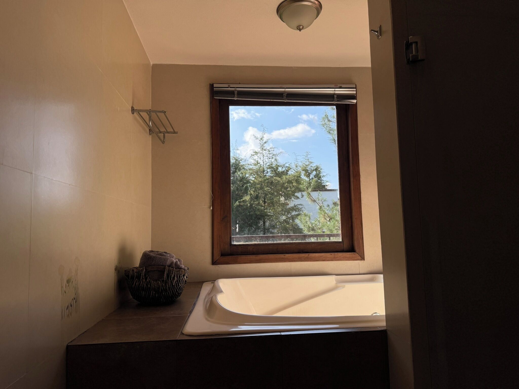 A bathroom with a window, a towel rack, and a sink.