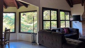 A spacious living room with large windows, a fireplace, and a cozy seating area. - Cabaña El Roble Mazamitla (Mazamitla)