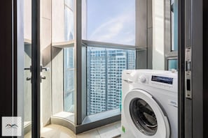 Compact laundry room with washing machine and balcony access.