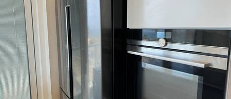 Uma geladeira Samsung de aço inoxidável e um forno Siemens em uma cozinha.