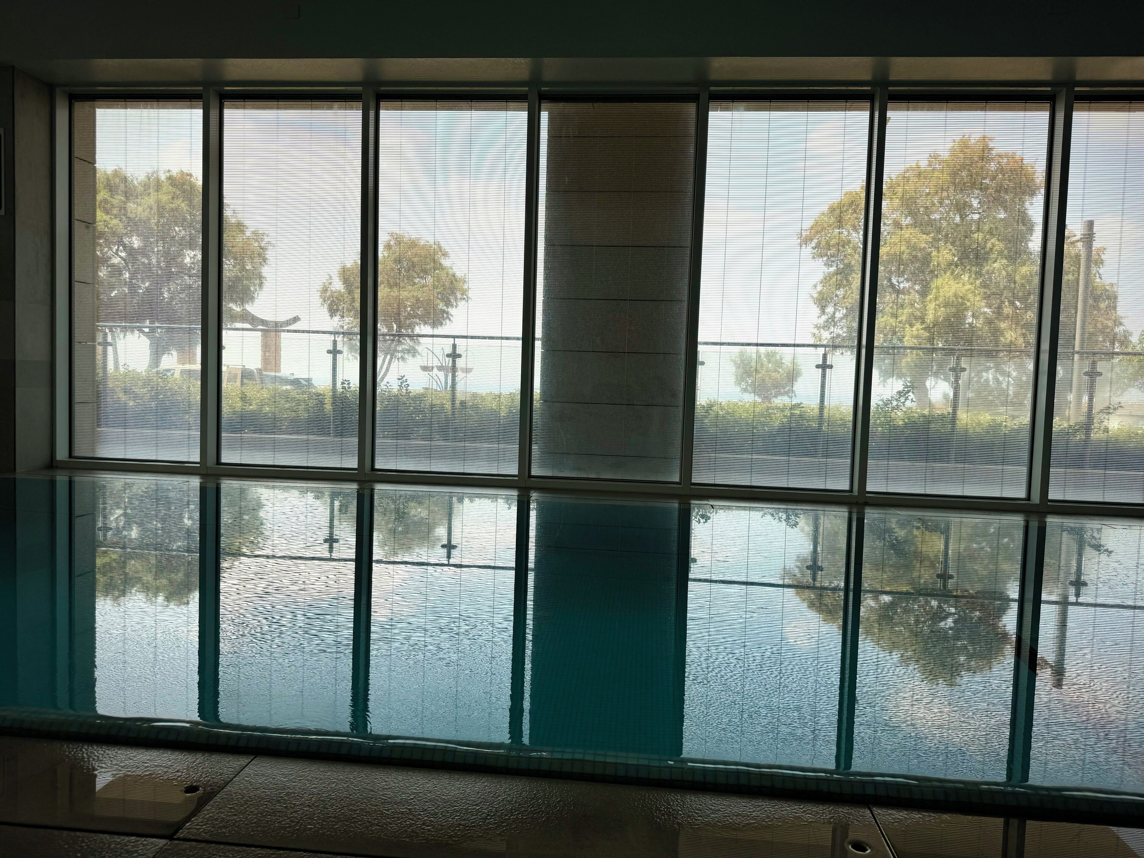 A room with large windows reflecting a street view.