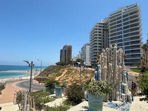 A coastal urban area with a beach, a curved road, and modern buildings. - Prince Palace Netanya Central Beach (Netanya)