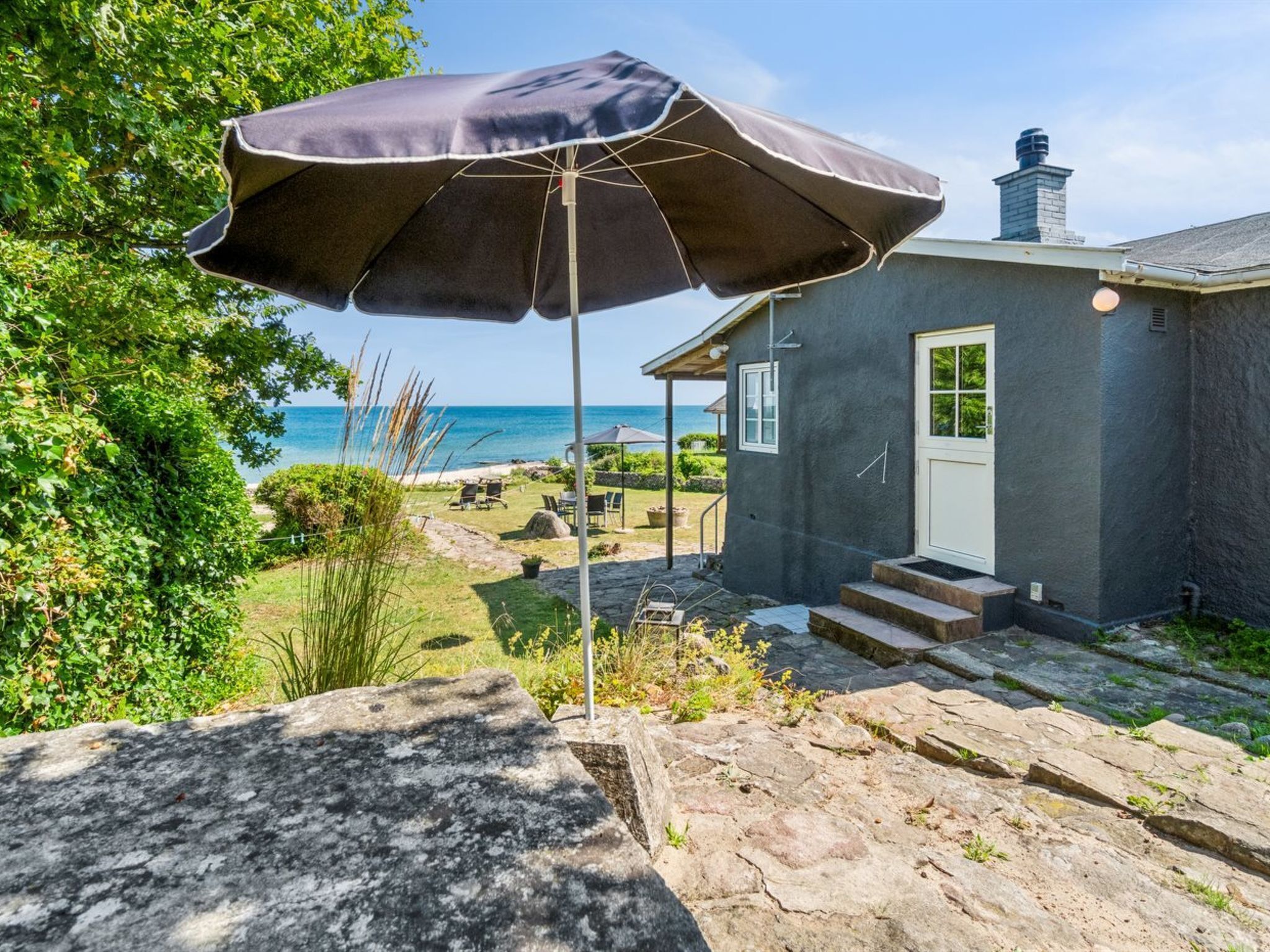 Ein Steinhaus mit einer kleinen Veranda, einer Tür und Stufen zum Eingang.