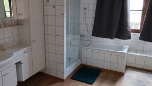 Un bagno con lavandino, specchio, doccia e vasca.