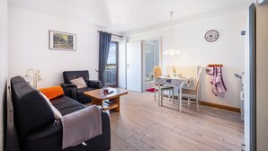 Una sala de estar moderna con un sofá, una mesa de centro y un comedor con una mesa y sillas.