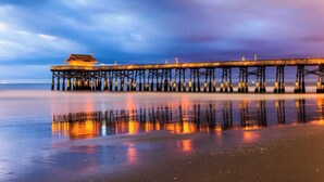 A pier extending into calm waters with a building at the end. - Welcome to Space Coast Retreat (Cocoa Beach)