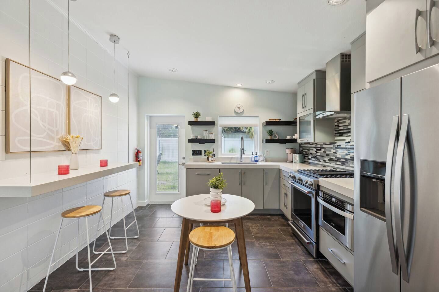 A modern kitchen with a central island, stainless steel appliances, and a view to the outdoors.