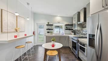 A modern kitchen with a central island, stainless steel appliances, and a view to the outdoors.
