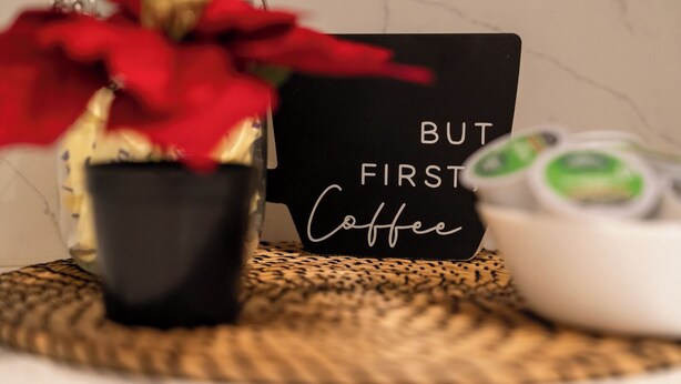 Un coin café comprenant un bocal, une pancarte noire et un bol.