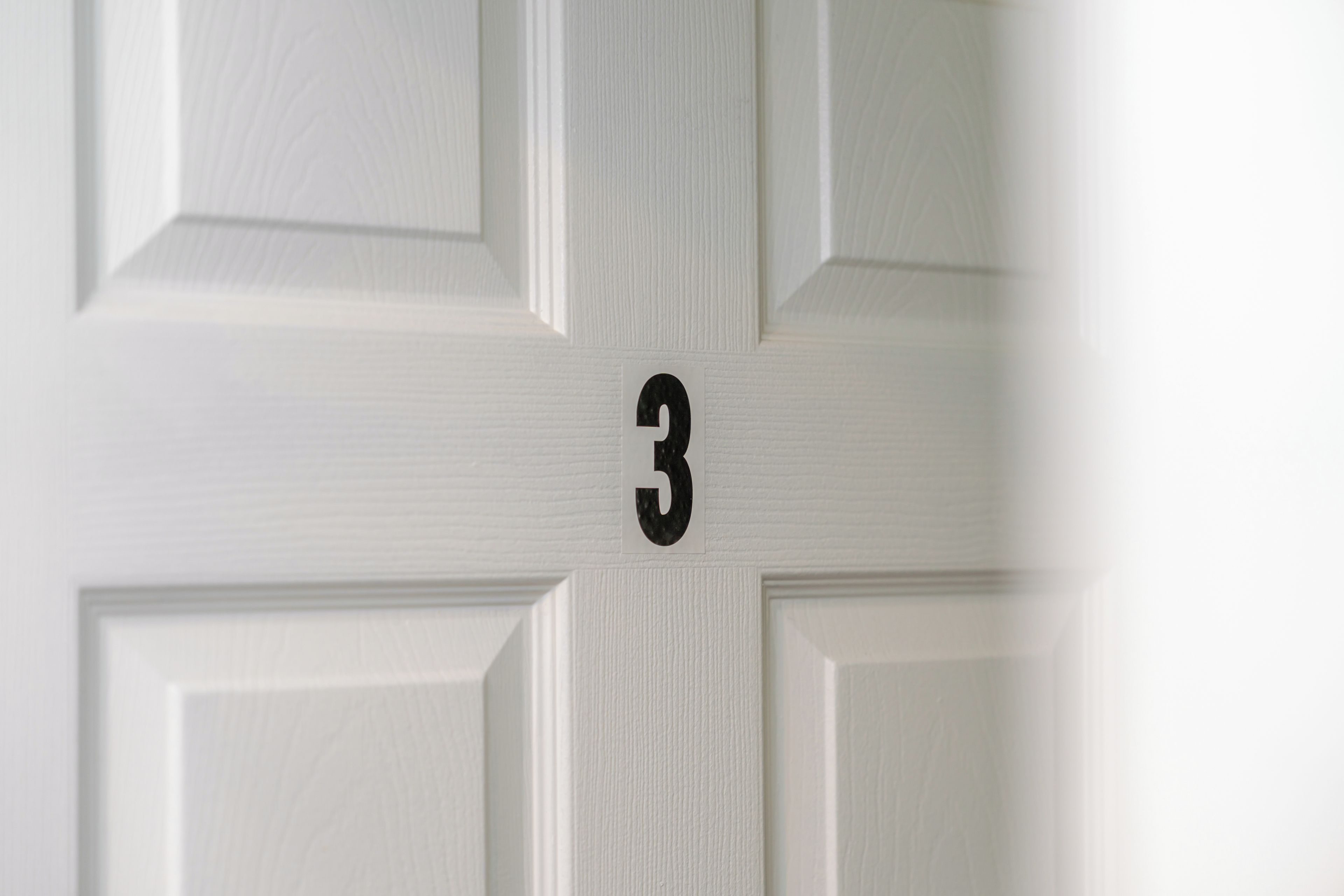 A white door with a number '3' indicating a room number.