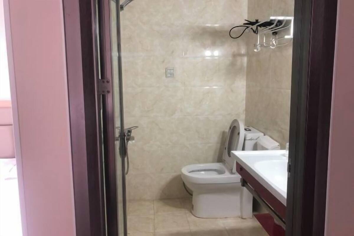 A bathroom with a toilet, sink, and shower area.
