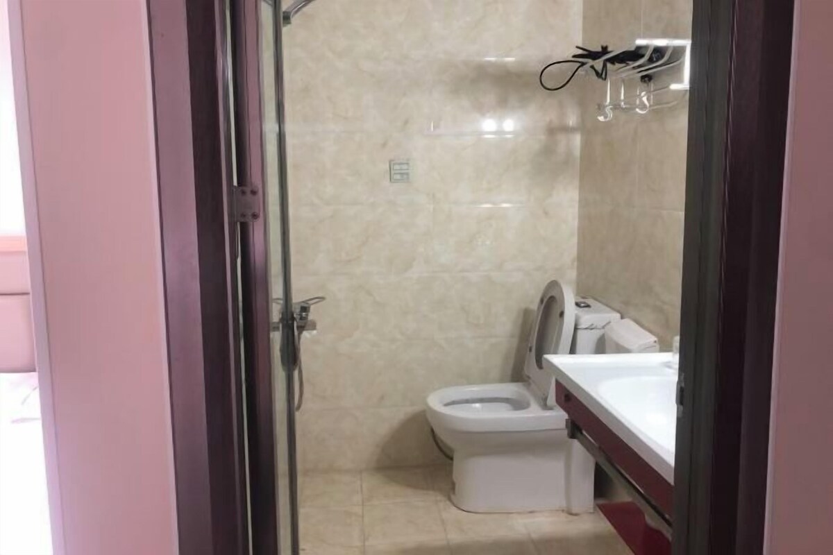 A bathroom with a toilet, sink, and glass shower enclosure.