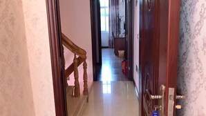 A hallway with a wooden staircase leading to a room. - Golden Bay 38 Homestay (Cangnan)
