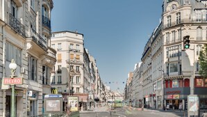 A street view with buildings, a Metro sign, and a McDonald's sign. - Luxueux Studio Cosy à Bastille (Paris)