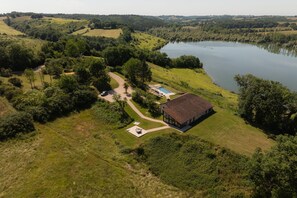 Escape to a serene lakeside retreat surrounded by lush greenery and rolling hills.