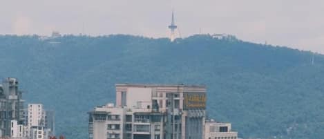 A cityscape with buildings and a hill in the background.