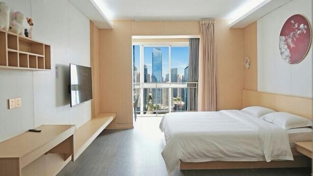 A hotel room with a bed, a TV, a balcony with a city view, and a desk. - Changsha Antman Good Living (Provincial Children's Hospital Yali Middle School) (Changsha)