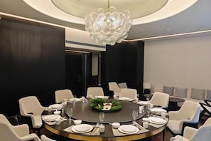 A modern dining room with a round table, white chairs, and a chandelier. - Nanyang Hotel, Jiaotong University, Xi'an (Jiaotong University Qinglong Temple) (Xi'an)