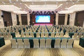 A conference room with rows of tables and chairs, a stage with a screen, and a chandelier. - Nanyang Hotel, Jiaotong University, Xi'an (Jiaotong University Qinglong Temple) (Xi'an)
