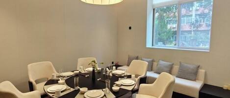 A dining area with a round table, chairs, and a sofa.