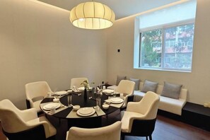 A dining area with a round table, chairs, and a sofa.