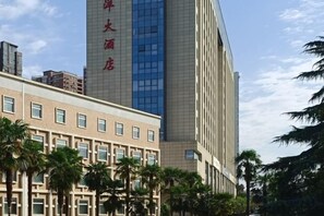 A hotel building with a modern facade, multiple floors, and a prominent vertical sign. - Nanyang Hotel, Jiaotong University, Xi'an (Jiaotong University Qinglong Temple) (Xi'an)