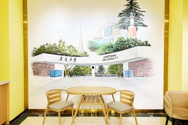 A mural of Jiutong University building with a table and chairs in front.