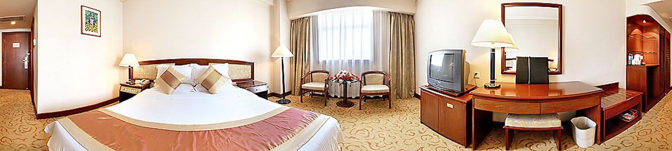 Une chambre d’hôtel avec un grand lit, un bureau avec une chaise, une télévision et une salle de bain.