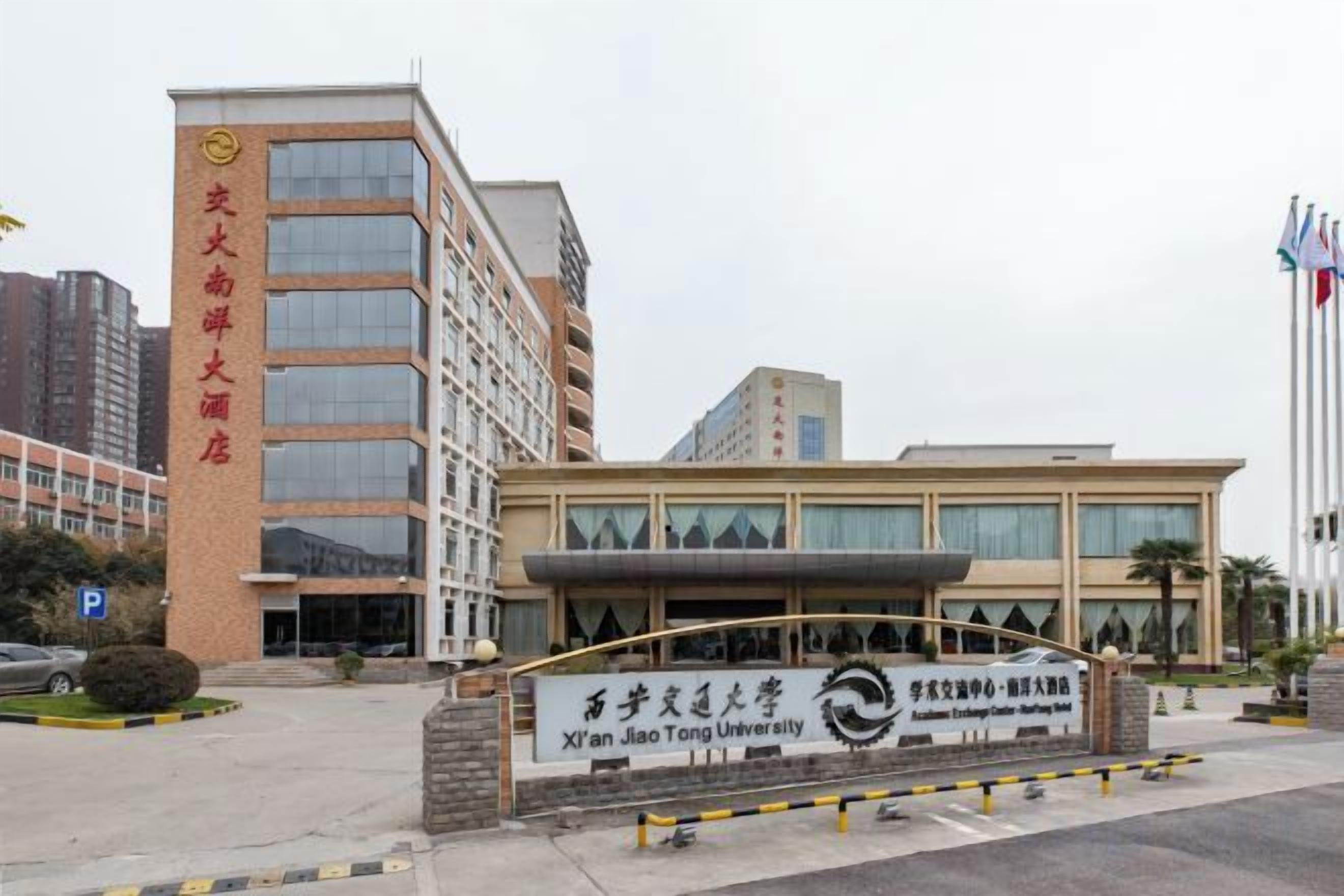 A building with a sign for Xian Jiaotong University and a large entrance.