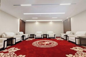 A conference room with a red carpet, white chairs, and tables. - Nanyang Hotel, Jiaotong University, Xi'an (Jiaotong University Qinglong Temple) (Xi'an)